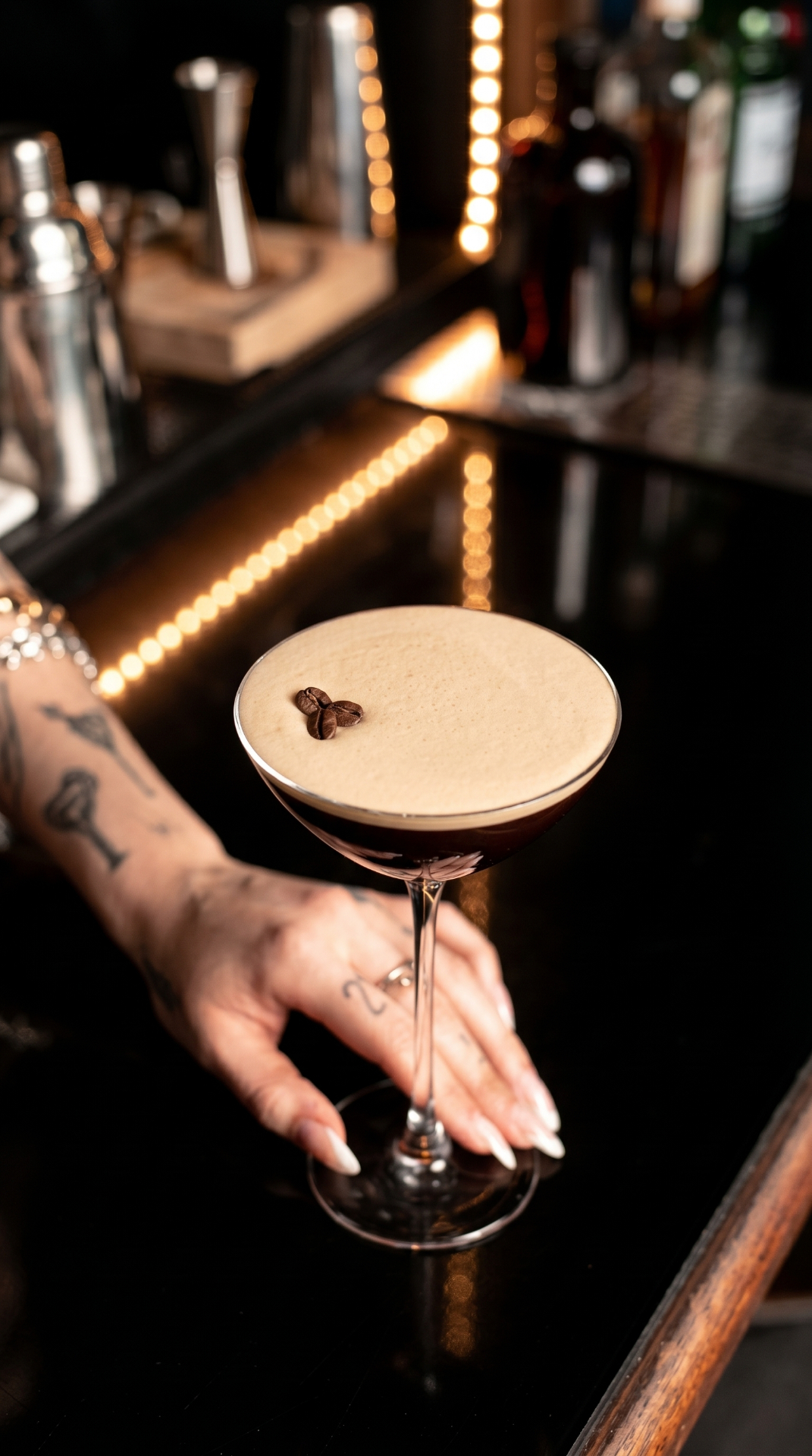 A poured espresso martini, held at the bar
