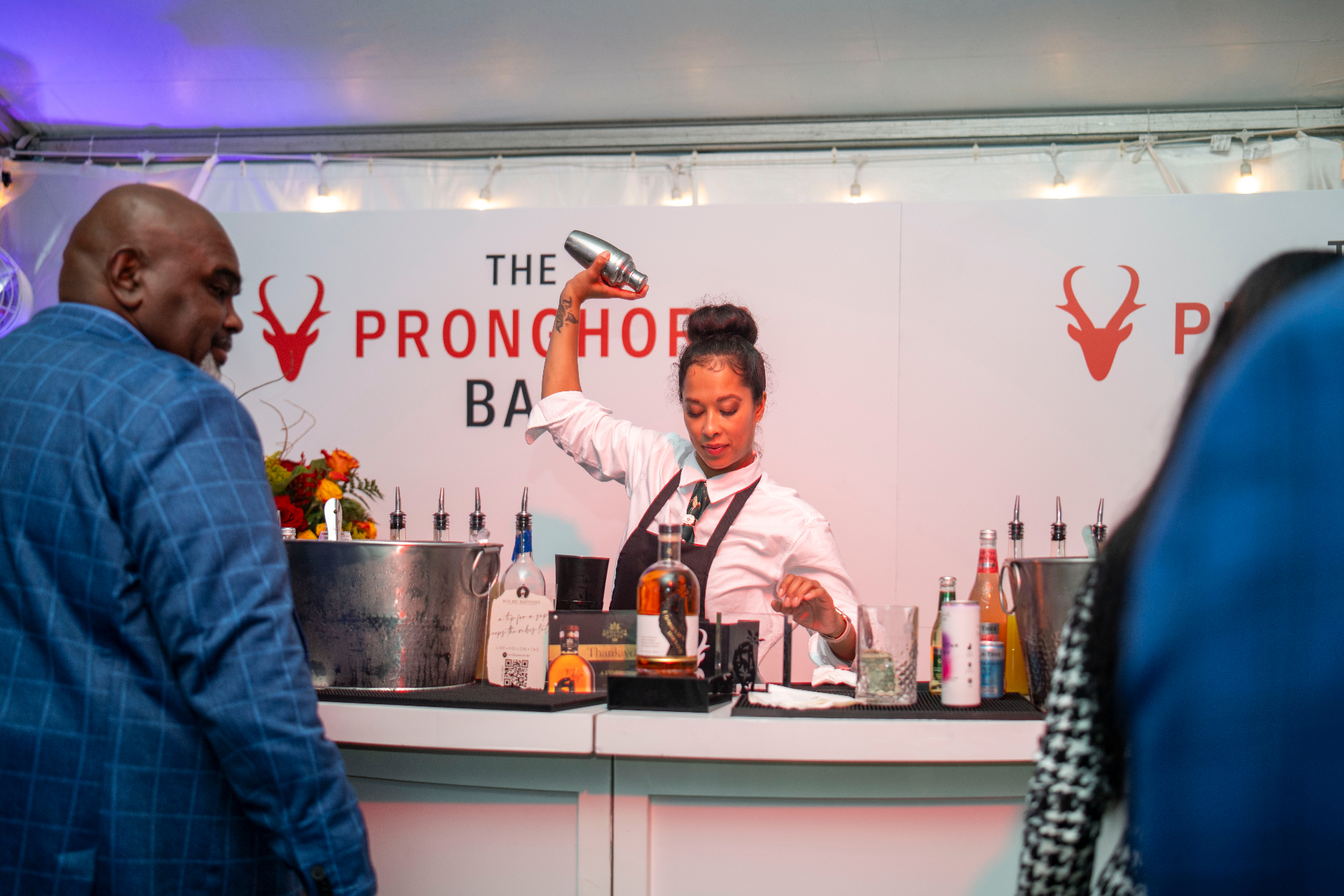 A bartender mid-shake at the Pronghorn Bar inside the Preakness tent