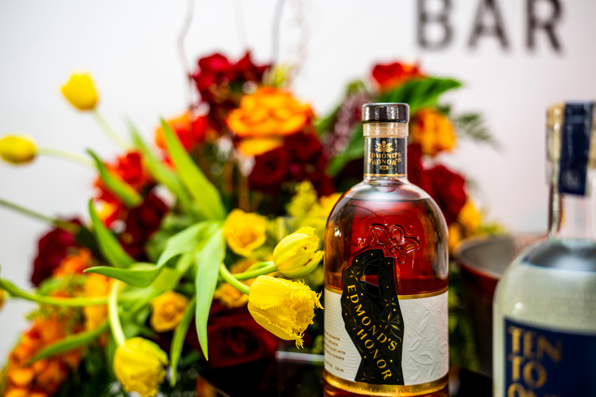 Edmond's Honor bourbon among red roses and yellow tulips at the Pronghorn Bar
